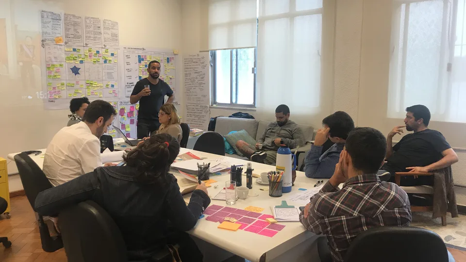 Grupo de trabalho com post-its sobre a mesa durante workshop de planejamento