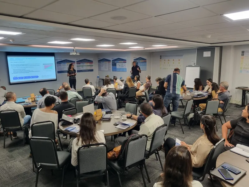 Workshop da Abbott com telão e grupos em mesas