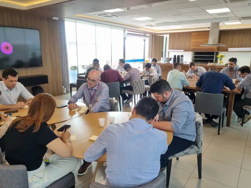 Sala de projeto com grupos em mesas de trabalho na Engie