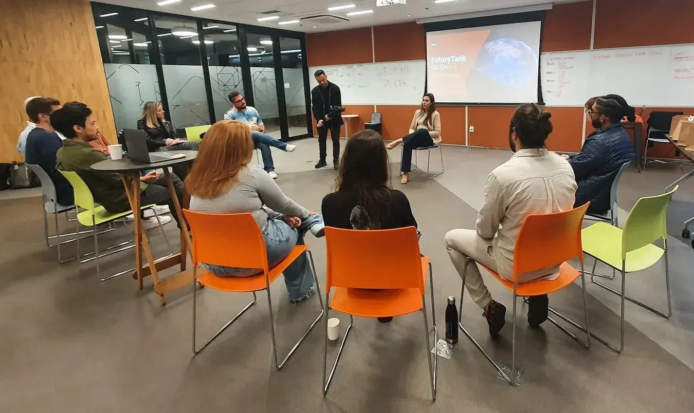 Workshop do time Itaú em sala com paredes cobertas de post-its e canvases